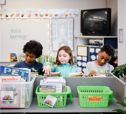 This is an image of students looking through a classroom library for a book to read